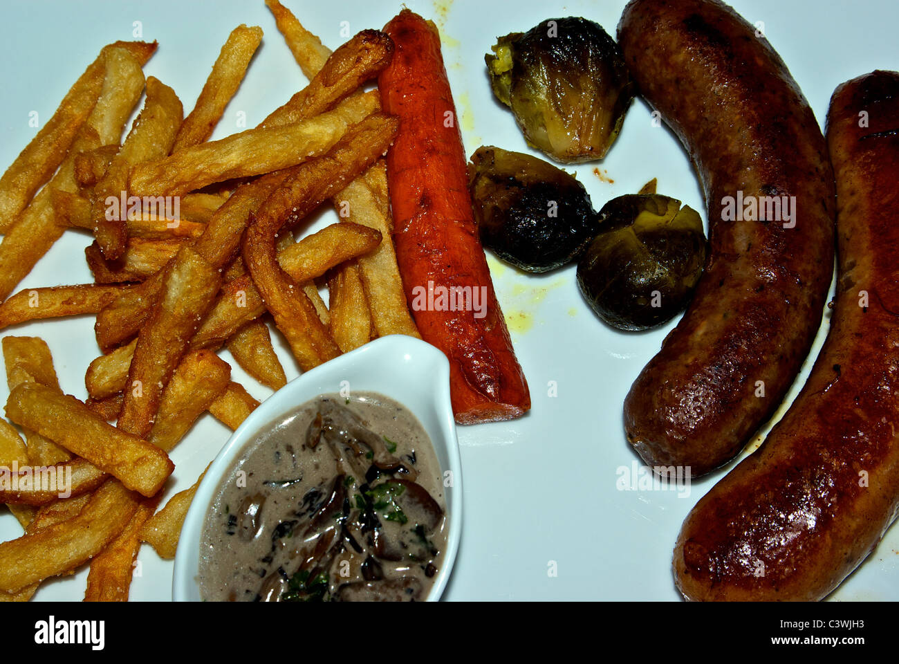 Plateau déjeuner viande de bison rôti au four Carottes Choux de Bruxelles  saucisses frites belges champignons étuvées Photo Stock - Alamy