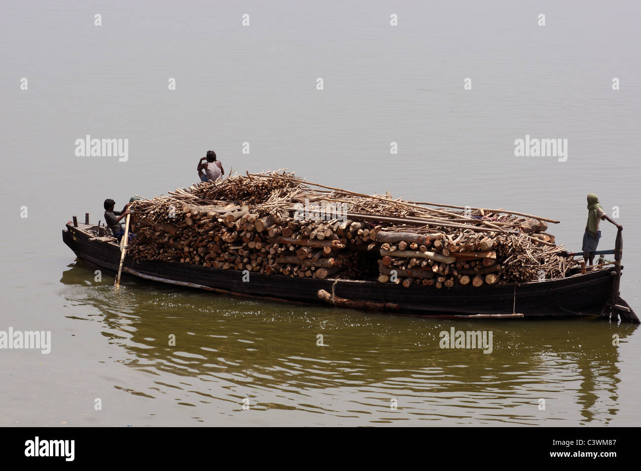 Bateau transportant du bois pour la combustion des Ghats à Ganges, Varanasi, Inde Banque D'Images Bateau transportant du bois pour la combustion des Ghats à Ganges, Varanasi, Inde Banque D'Images