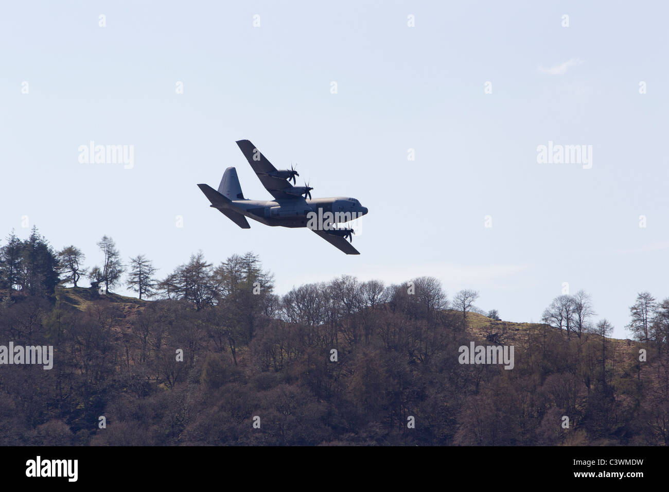 Le Lockheed C-130 Hercules quatre turbopropulseurs de transport militaire à basse altitude au-dessus du lac Windermere Loweswater hauteurs Banque D'Images