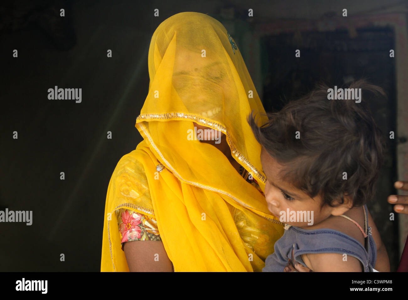 Une femme vêtue de vêtements traditionnels tenant son enfant à Udaipur, Rajasthan, Inde Banque D'Images