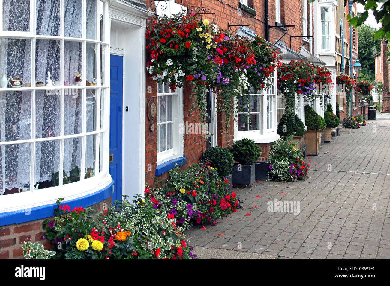 Paniers suspendus colorés de fleurs et bains à remous dans Broad Street, Pershore, Worcestershire, Angleterre, RU Banque D'Images