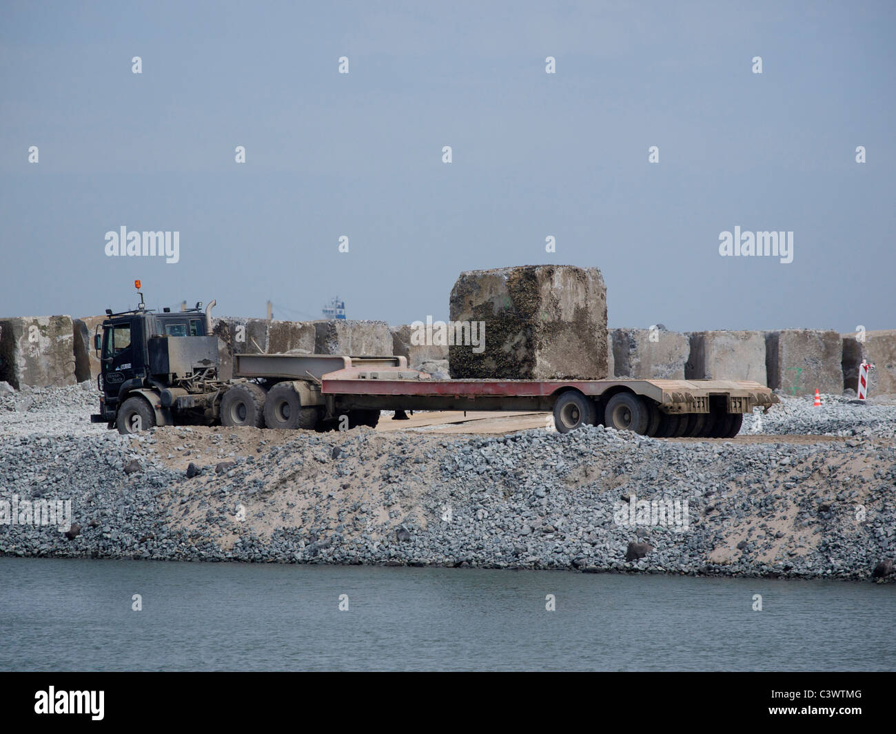 Camion transportant 40 tonnes d'un seul bloc de béton utilisé pour un obstacle dans la mer du Nord. Rotterdam Pays-Bas Banque D'Images