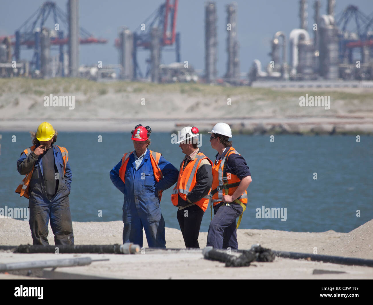 Les hommes discutent de leur travail dans le port de Rotterdam, la construction de la nouvelle zone Maasvlakte 2 aux Pays-Bas. Banque D'Images Les hommes discutent de leur travail dans le port de Rotterdam, la construction de la nouvelle zone Maasvlakte 2 aux Pays-Bas. Banque D'Images