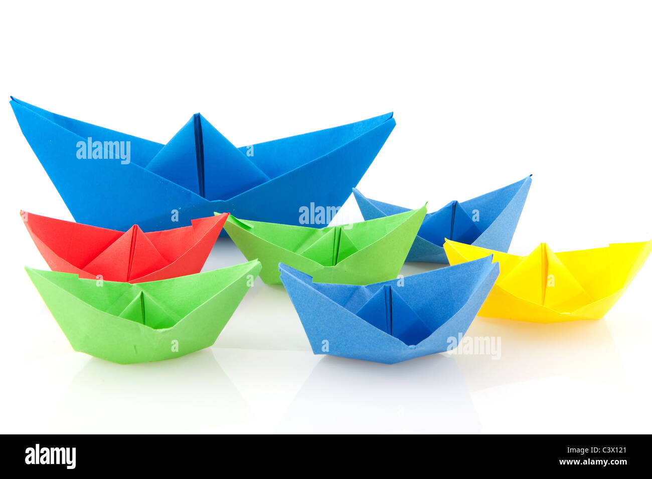 De nombreux bateaux de papier pliée colorés sur fond blanc Banque D'Images