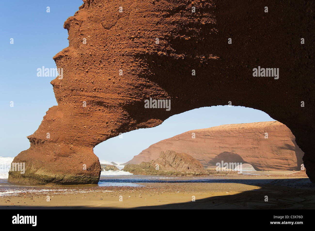 Rock arches sur la plage de Legzira sur l'océan Atlantique, 11 km au nord de la ville de Sidi Ifni, dans le sud-ouest du Maroc. Banque D'Images