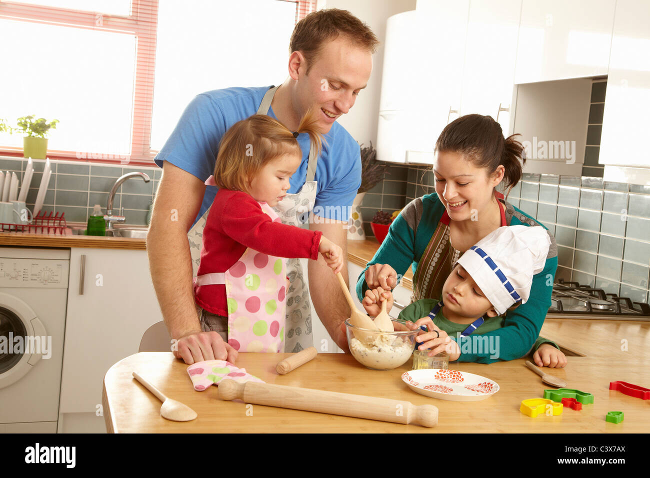 Jeune famille cooking together in kitchen Banque D'Images