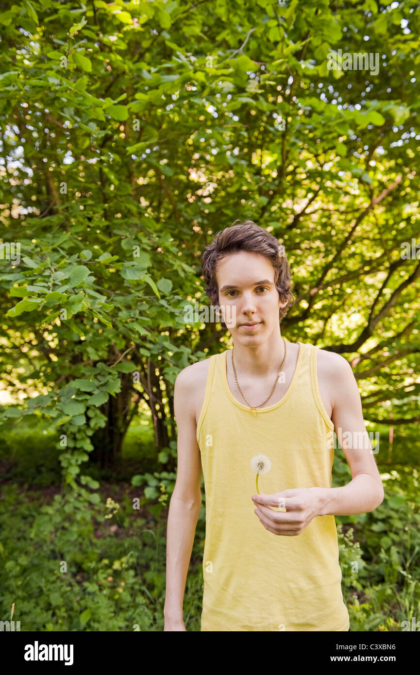 Young man holding dandelion Banque D'Images