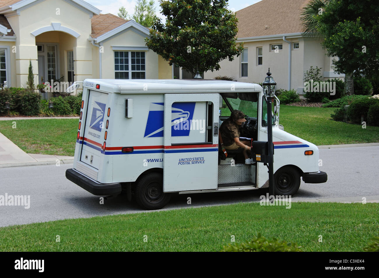 United States Postal Service van sur un immeuble d'habitation Floride USA Mail dame la collecte le courrier dans la boîte aux lettres Banque D'Images