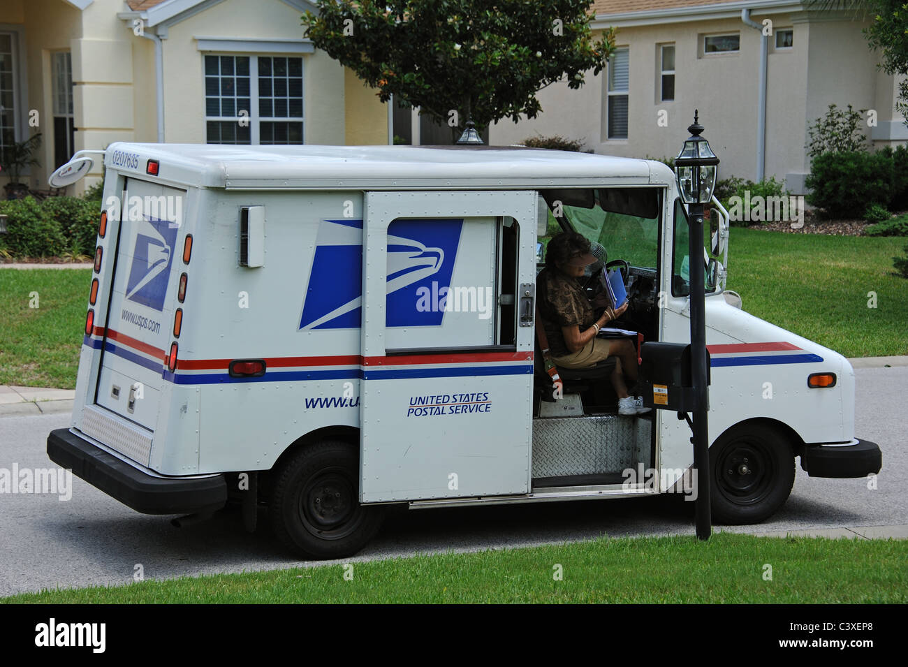 United States Postal Service van sur un immeuble d'habitation Floride USA Mail dame la collecte le courrier dans la boîte aux lettres Banque D'Images