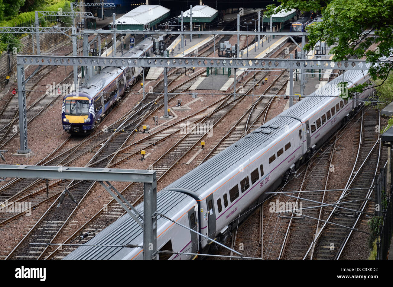 Un train arrive à la côte est comme un Scotrail Waverley train part. Banque D'Images