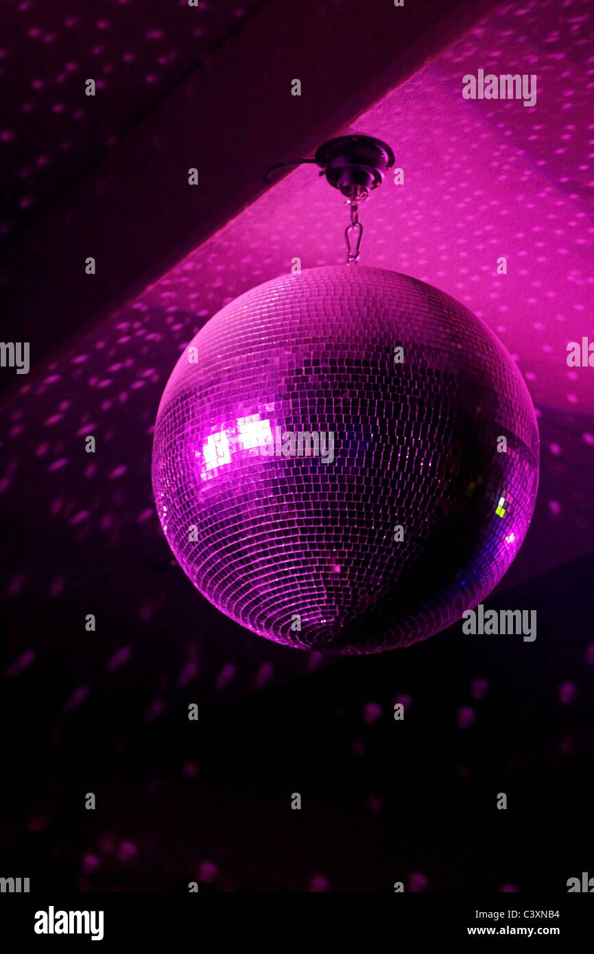 Boule disco en mouvement reflétant la lumière rose dans night club avec  copie-space Photo Stock - Alamy