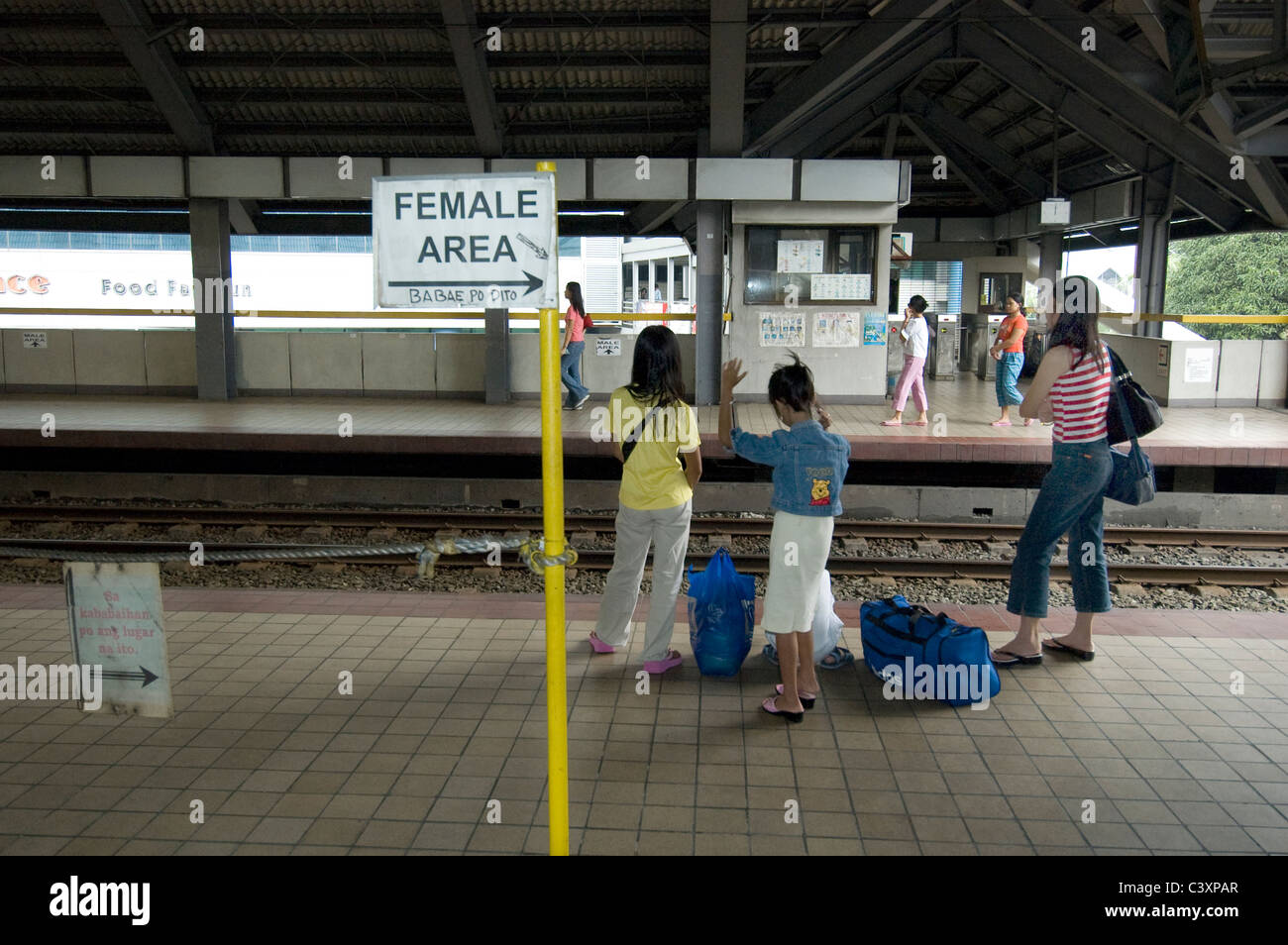 Les femmes sont dans la zone d'attente des femmes sur une plate-forme du train. Banque D'Images