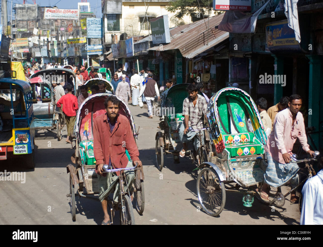 Rickshaw wallahs peddle en bas de la rue. Banque D'Images