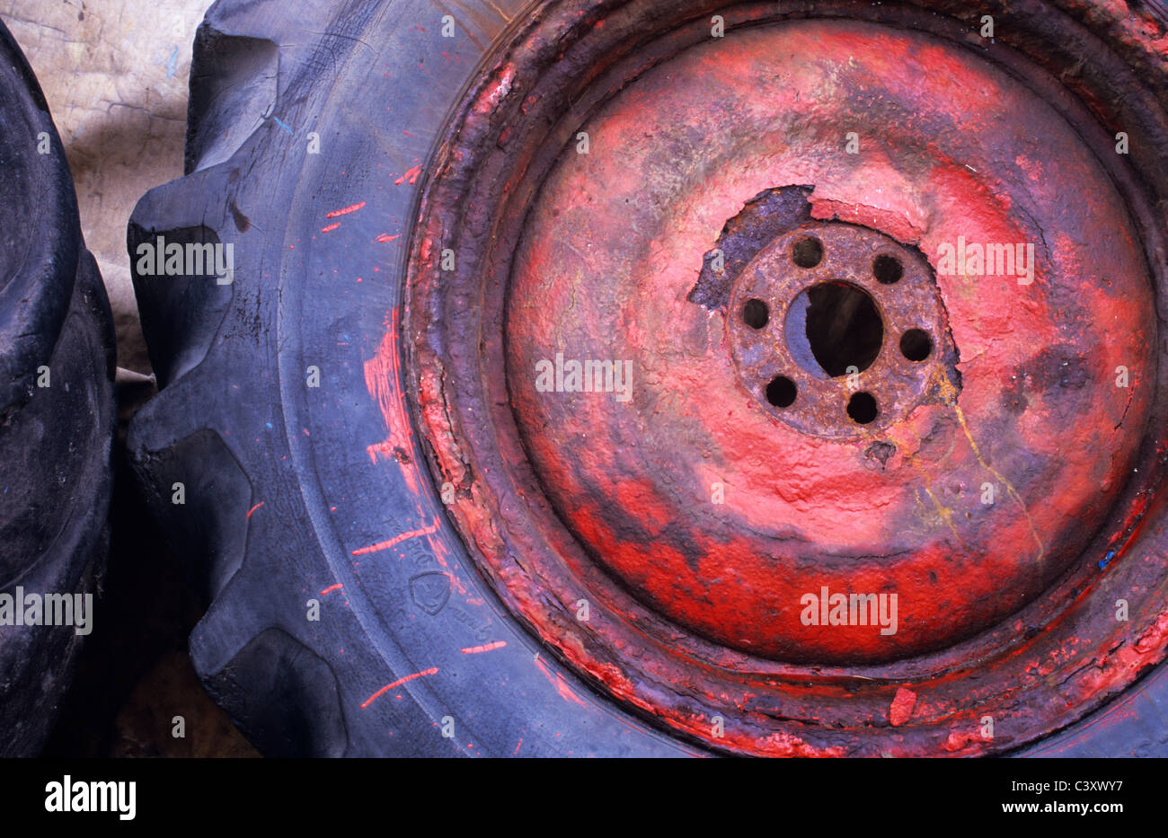 Détail de grande bande de roulement profonde avec des pneus du tracteur et la rouille noeud rouge peint négligemment auparavant avoir menti sur bâche Banque D'Images