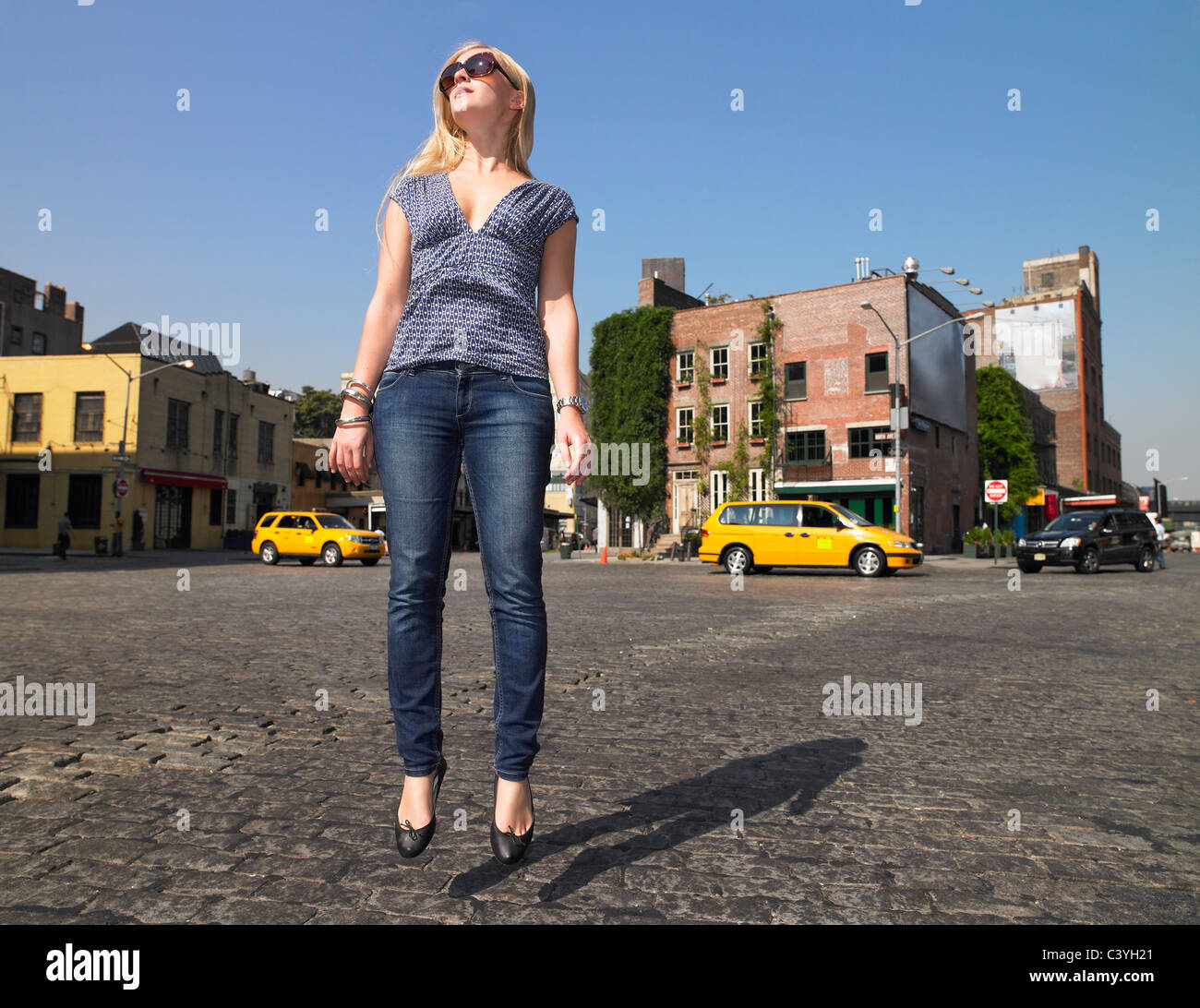 Femme sautant au milieu de street Banque D'Images
