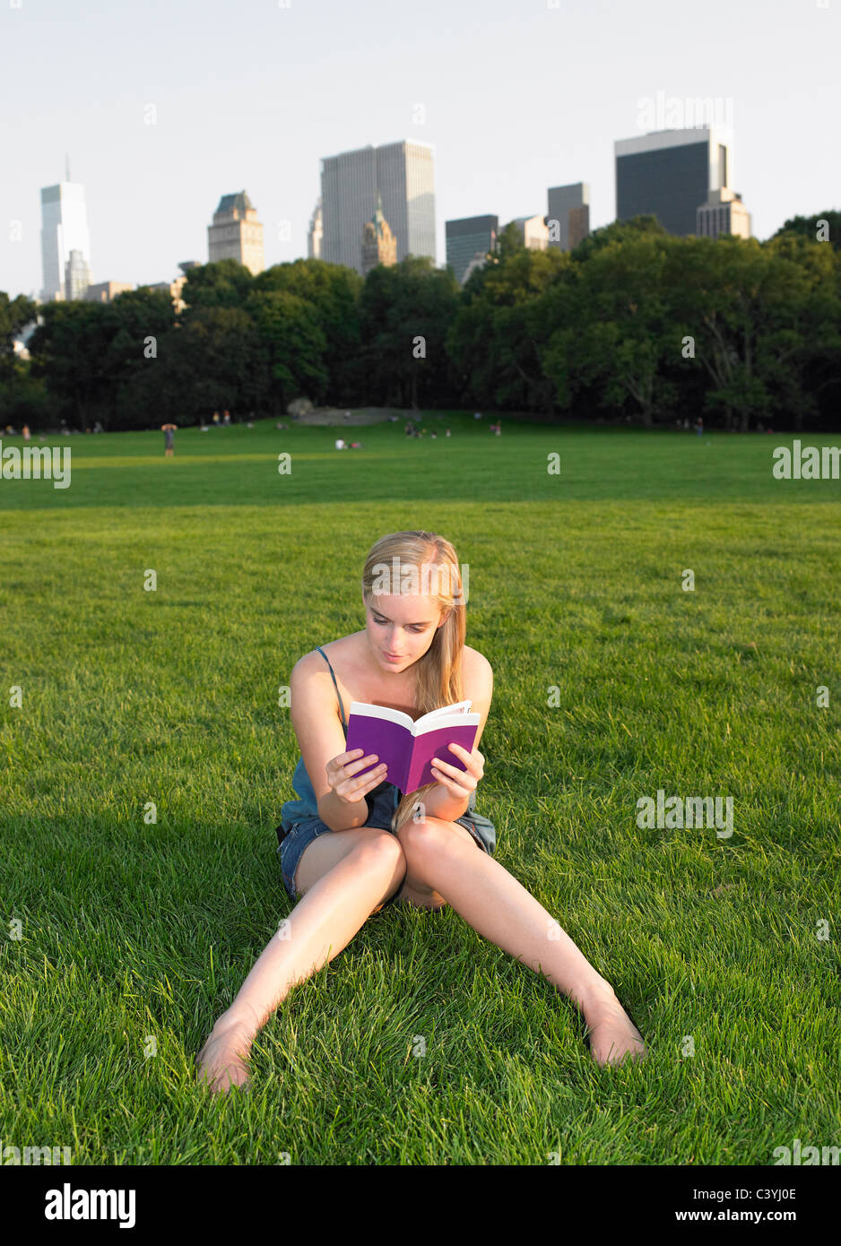 Woman Reading a book in central park Banque D'Images