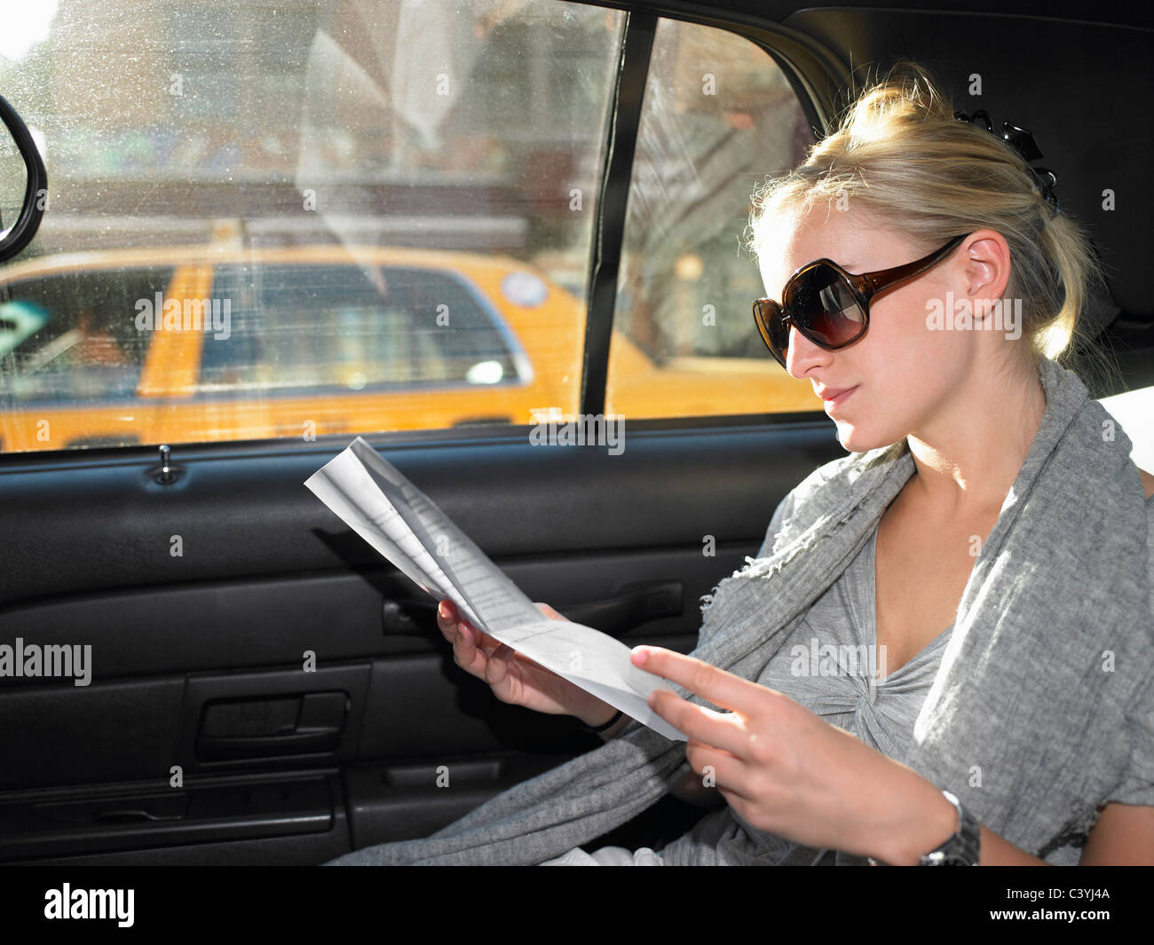 Femme lisant une lettre dans un taxi Banque D'Images
