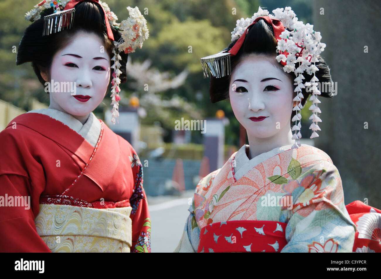 Deux belles geishas posent à l'extérieur un jour de printemps à Kyoto, au Japon. Banque D'Images