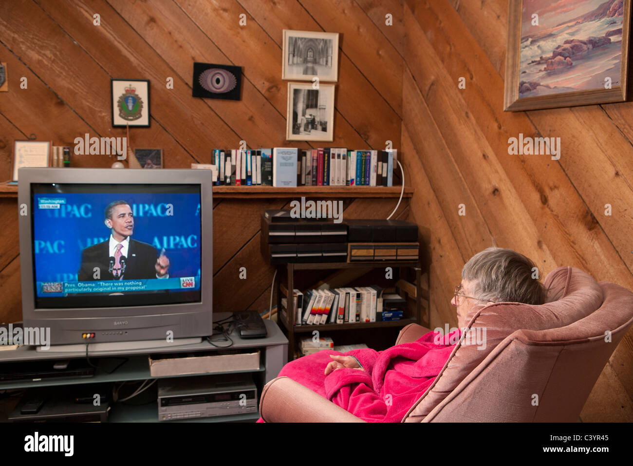 Senior lady regarder le président Obama à la télévision avant le coucher-Victoria, Colombie-Britannique, Canada. Banque D'Images