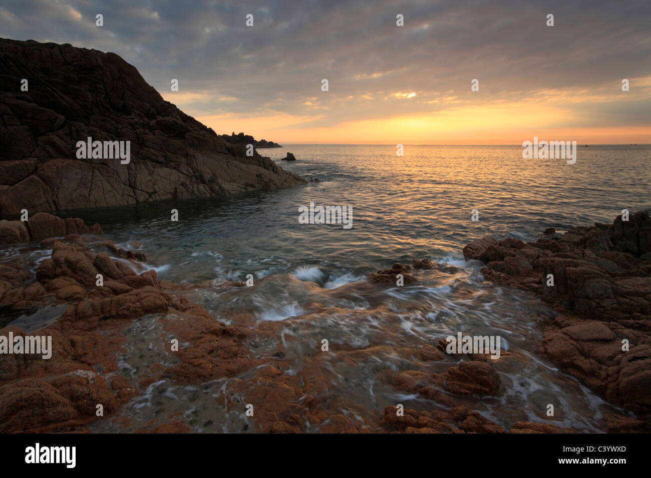 Coucher du soleil sur les teintes roches rouges de Point aux malades sur la côte ouest de Guernesey dans les îles de la manche de l'Angleterre Banque D'Images