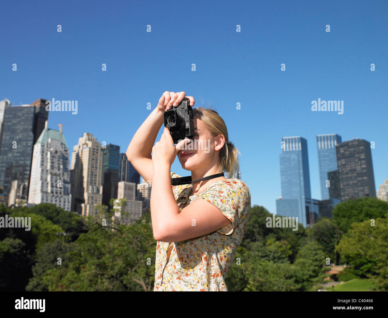 Woman taking pictures in central park Banque D'Images