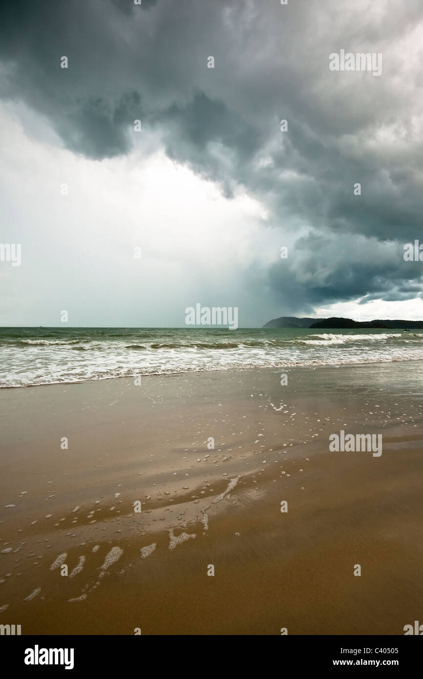 Longue plage de sable doré et de la tempête tropicale à Langkawi, Malaisie. Banque D'Images