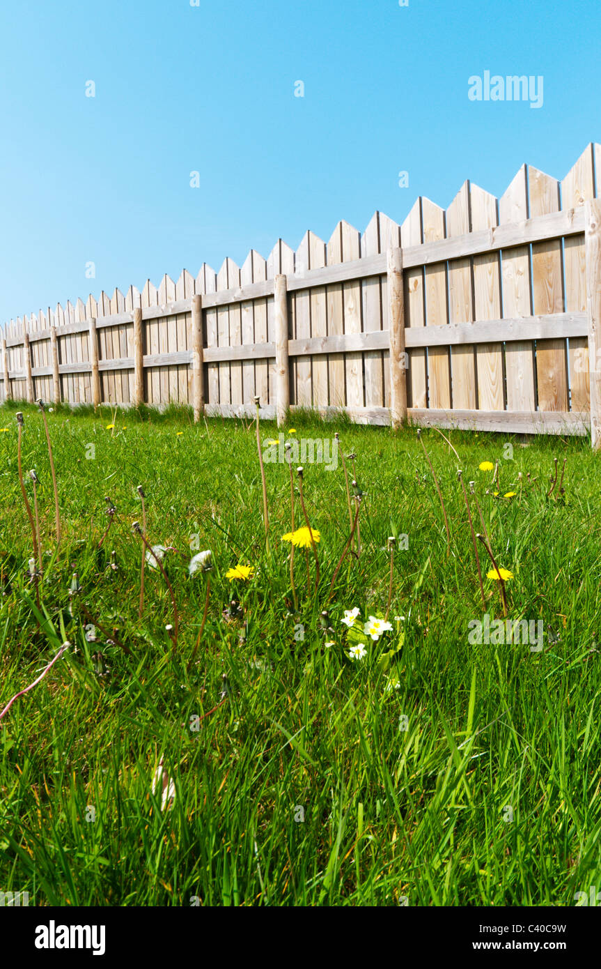 Une clôture de jardin en bois vu contre un ciel bleu clair. Banque D'Images