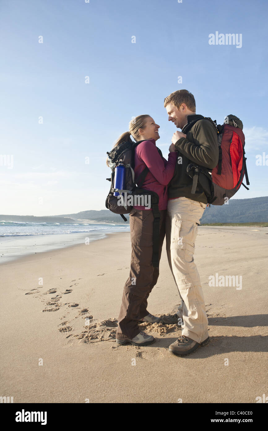 Backpacking couple hugging at beach Banque D'Images