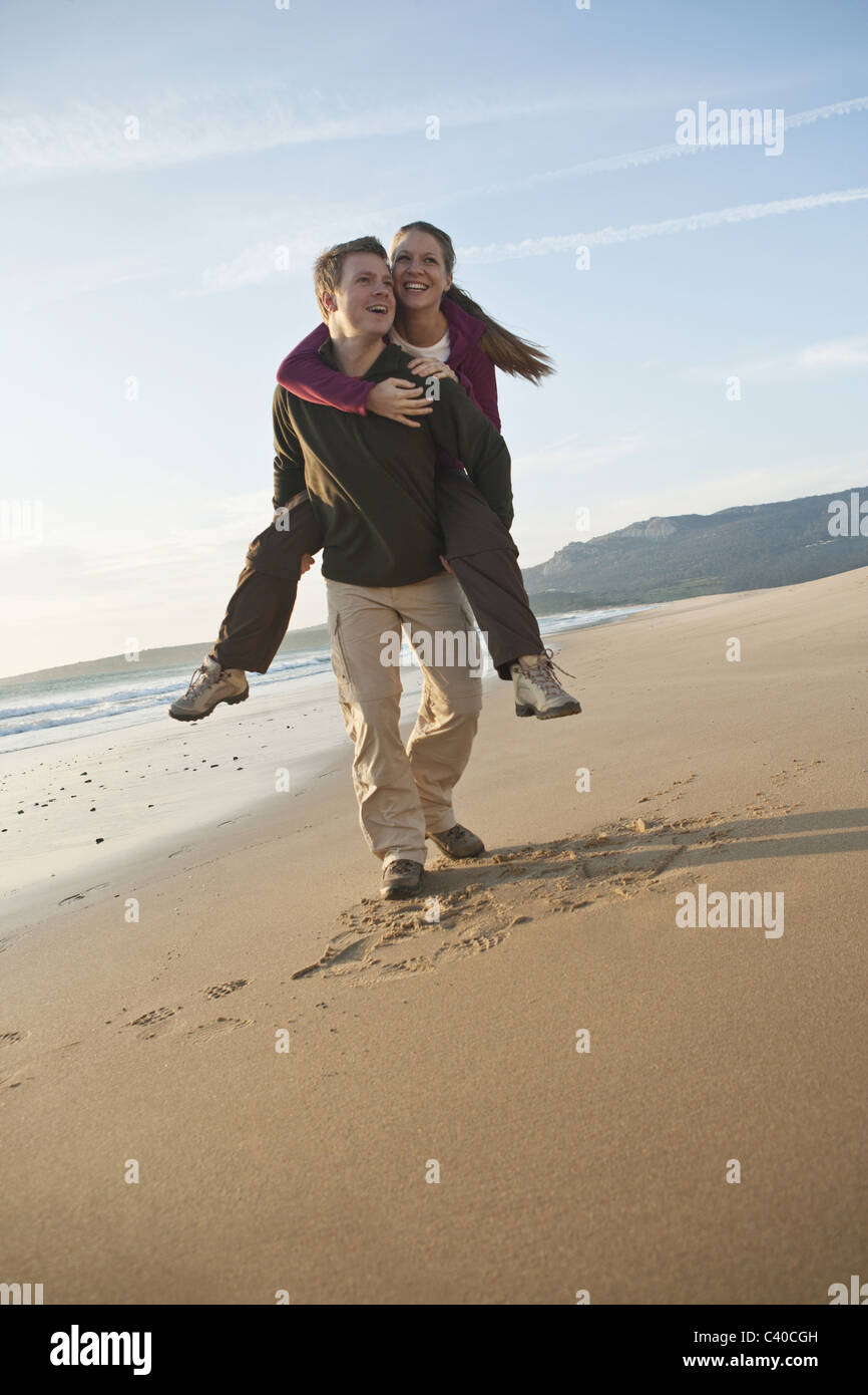 Young man giving woman piggyback ride Banque D'Images