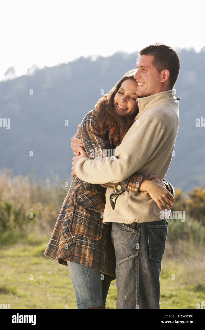 Young couple embracing in rural scene Banque D'Images