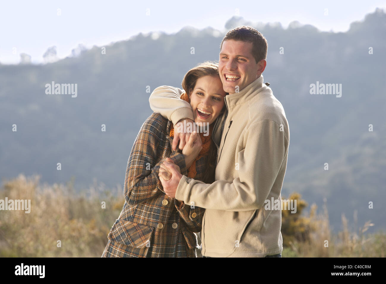 Young couple embracing in rural scene Banque D'Images