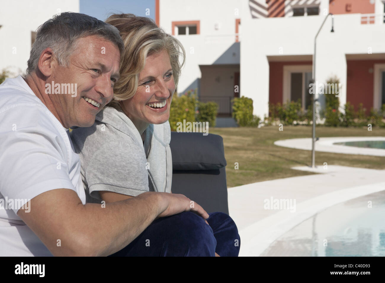 Mature couple relaxing by pool Banque D'Images
