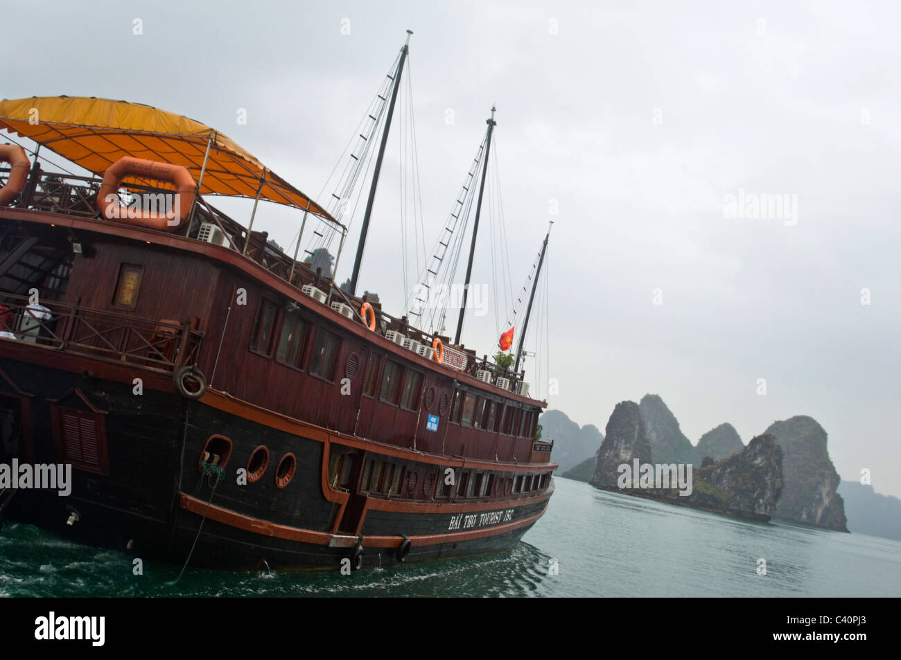 Vue horizontale de karsts calcaire (roches) dans la baie d'Halong et un indésirable en bois traditionnels utilisés pour les guides voile adopté. Banque D'Images