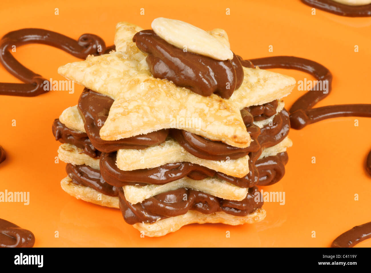 Crème au Chocolat en forme d'amande et le millefeuille sur une plaque orange. Focus sélectif. Banque D'Images