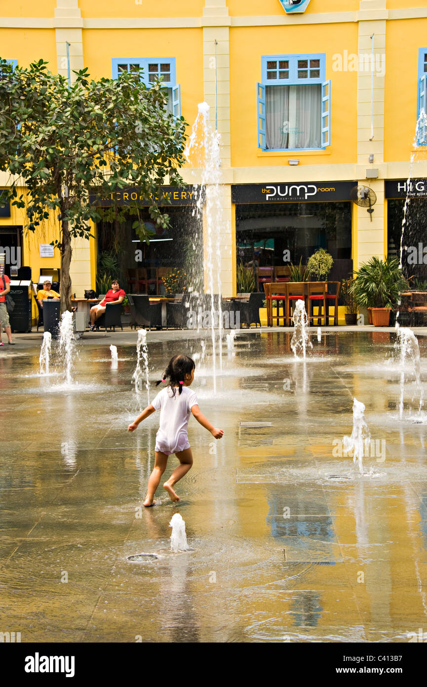 Le jeune enfant s'exécute par le biais de petites fontaines à jet d'eau en mètres carrés à Clarke Quay Shopping en République de Singapour Asie Banque D'Images