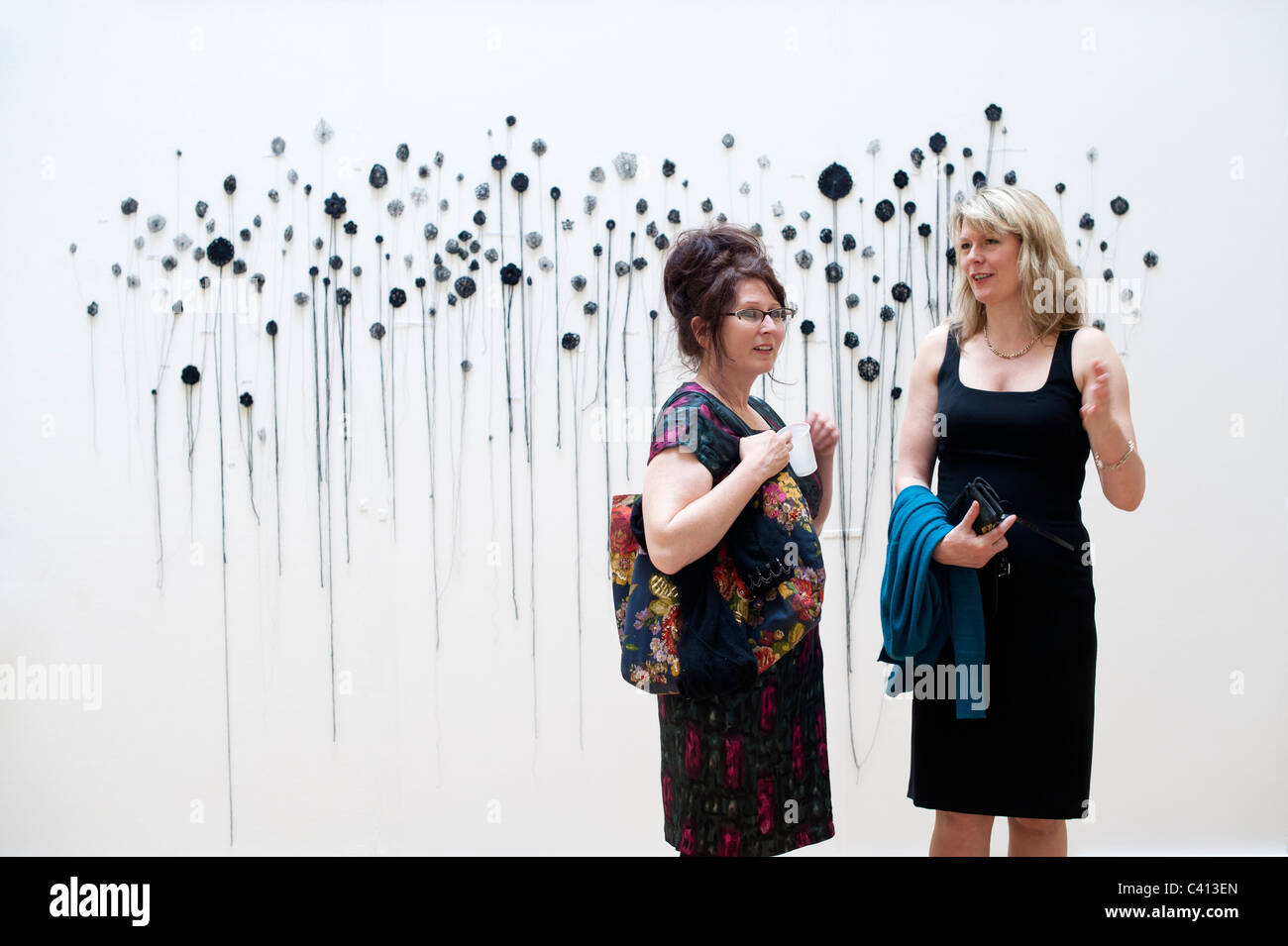 Deux femmes dans la galerie au baccalauréat voir exposition dans l'École d'art de l'Université d'Aberystwyth, Pays de Galles, Royaume-Uni Banque D'Images