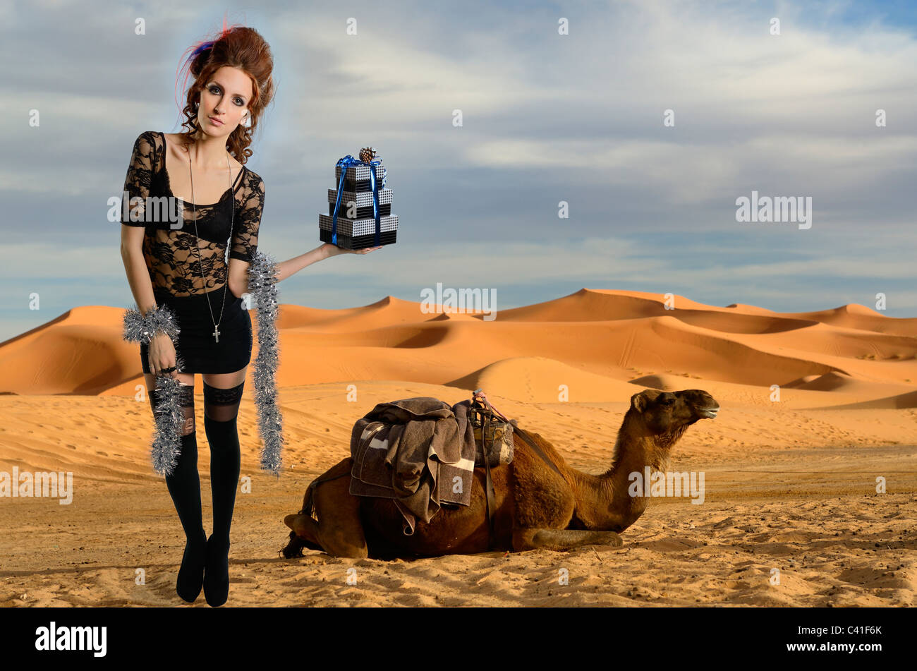 Femme avec des dons et des dromadaire désert erg Chebbi dunes de sable d'or composite maroc Banque D'Images