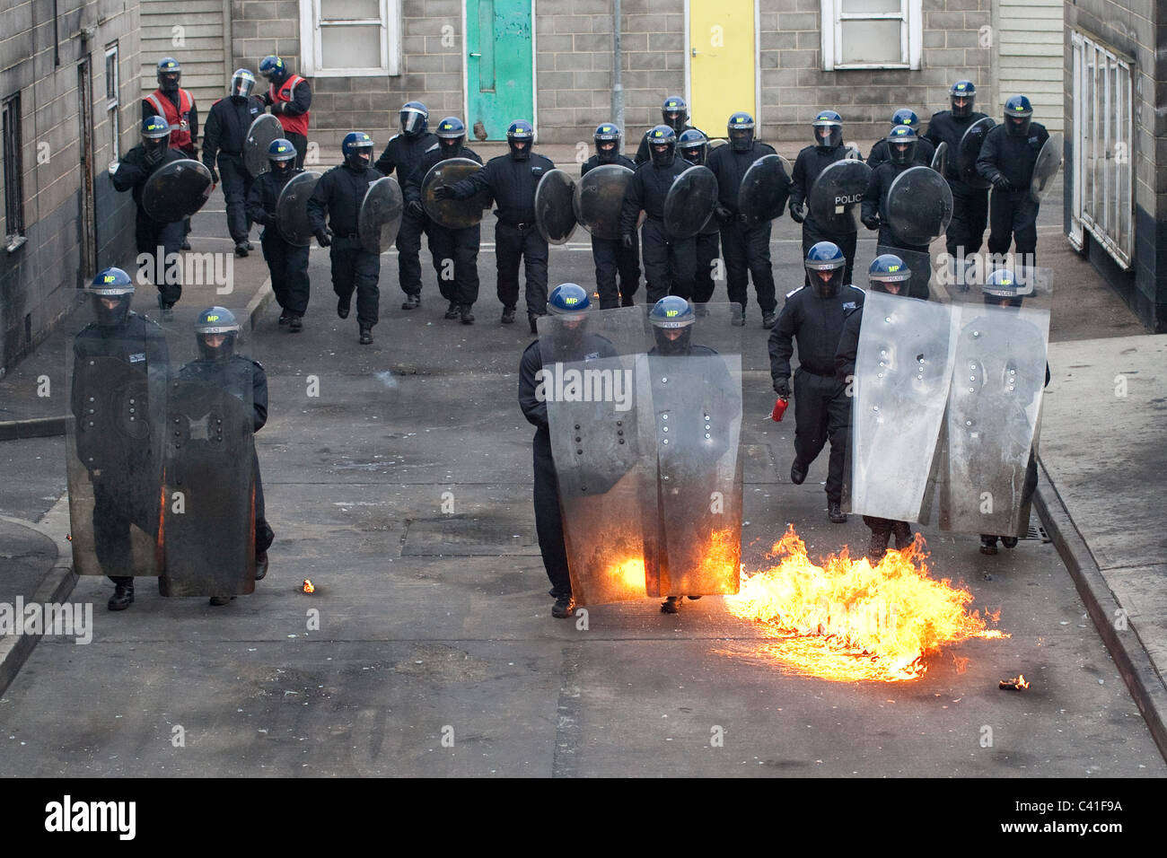 Une escouade de la police britannique à l'avance par des cocktails Molotov lors d'émeute de la formation. Banque D'Images