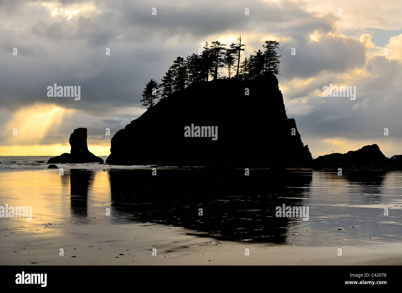 Silhouette de pile de la mer à l'étape de la deuxième plage. Un arbre de lumière perce les nuages. Banque D'Images