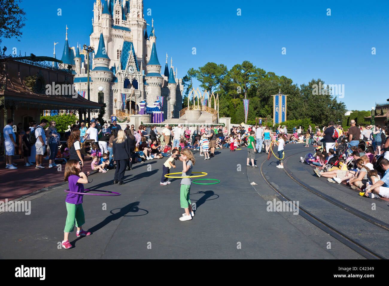 Les enfants jouent avec des hula-Hoops dans la rue en attendant la parade A Dream Come True au Magic Kingdom Banque D'Images