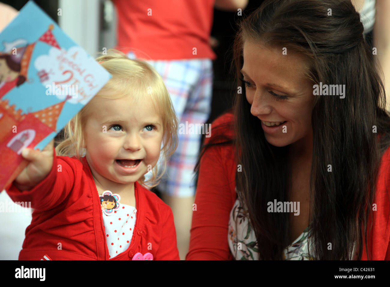 Fillette de deux ans avec sa maman montrant sa carte d'anniversaire Banque D'Images