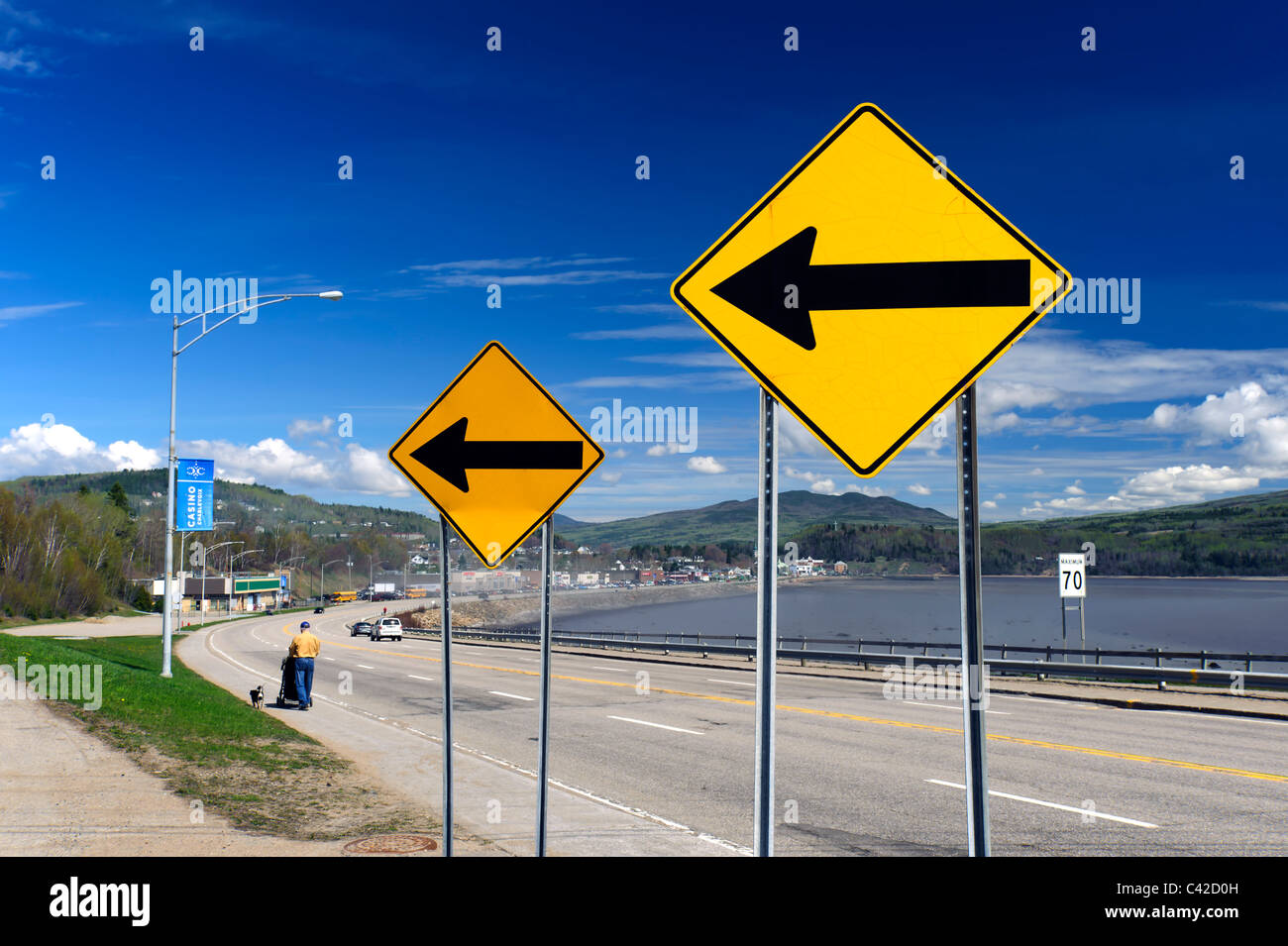Deux panneaux de signalisation jaune avec des flèches pointant vers la gauche, sur le boulevard de Comporté, La Malbaie, Québec, Canada Banque D'Images