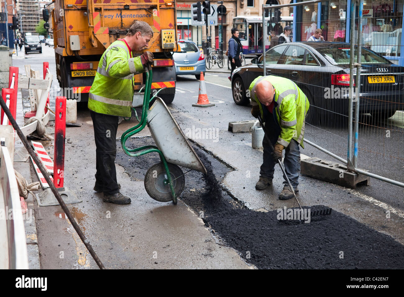 Deux ouvriers de la réparation d'une surface de la route, Glasgow, Écosse, Royaume-Uni Banque D'Images