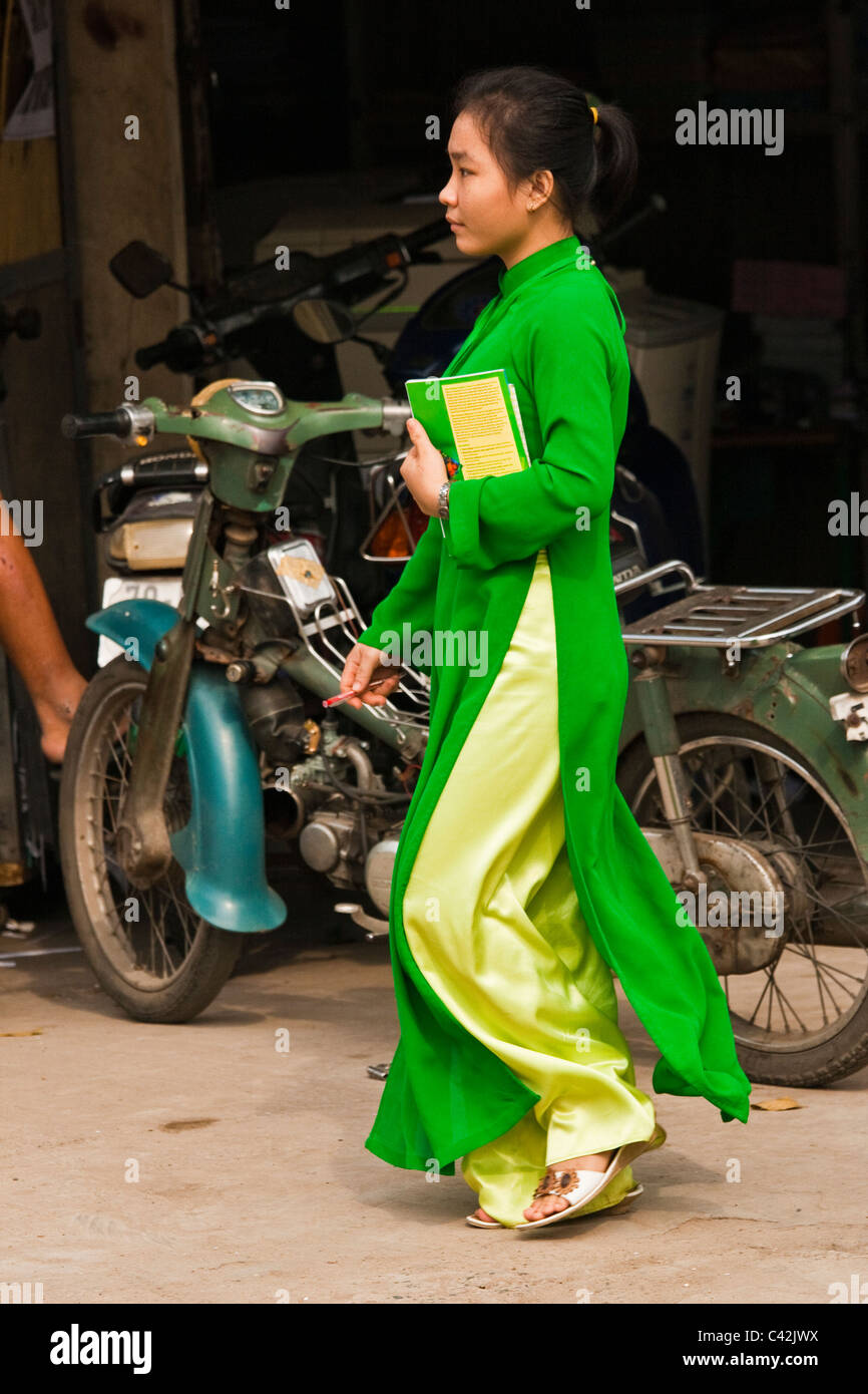 Student wearing Ao Dai à l'école à pied Banque D'Images