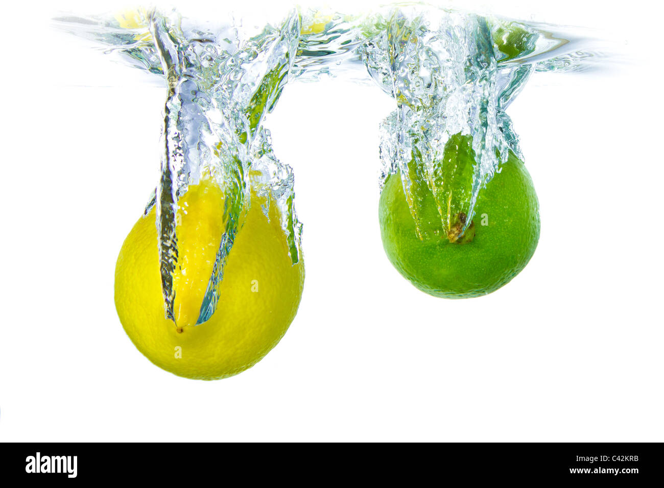 Lime et citron aux projections d'eau isolé sur fond blanc Banque D'Images