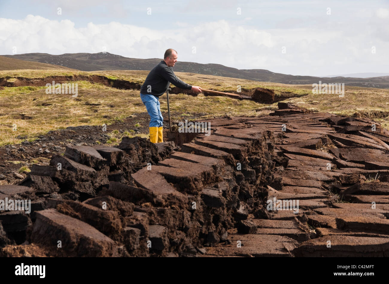 Coupe homme empilés pour le séchage des blocs de tourbe comme combustible traditionnel. Les Îles Shetland, Écosse, Royaume-Uni, Europe. Banque D'Images