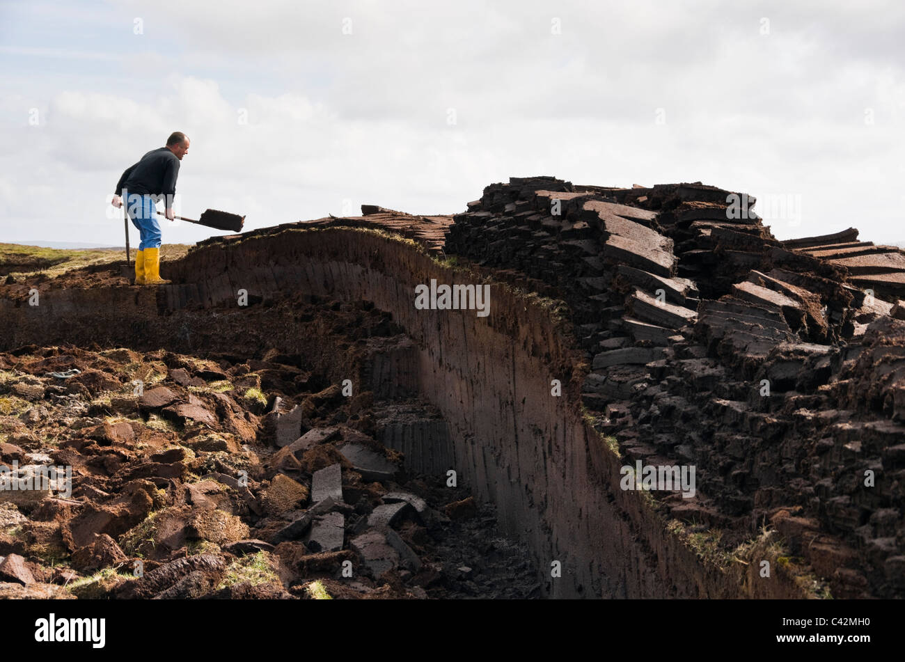Coupe homme pour des blocs de tourbe combustible traditionnel sur les îles Shetland, Écosse, Royaume-Uni, Angleterre Banque D'Images