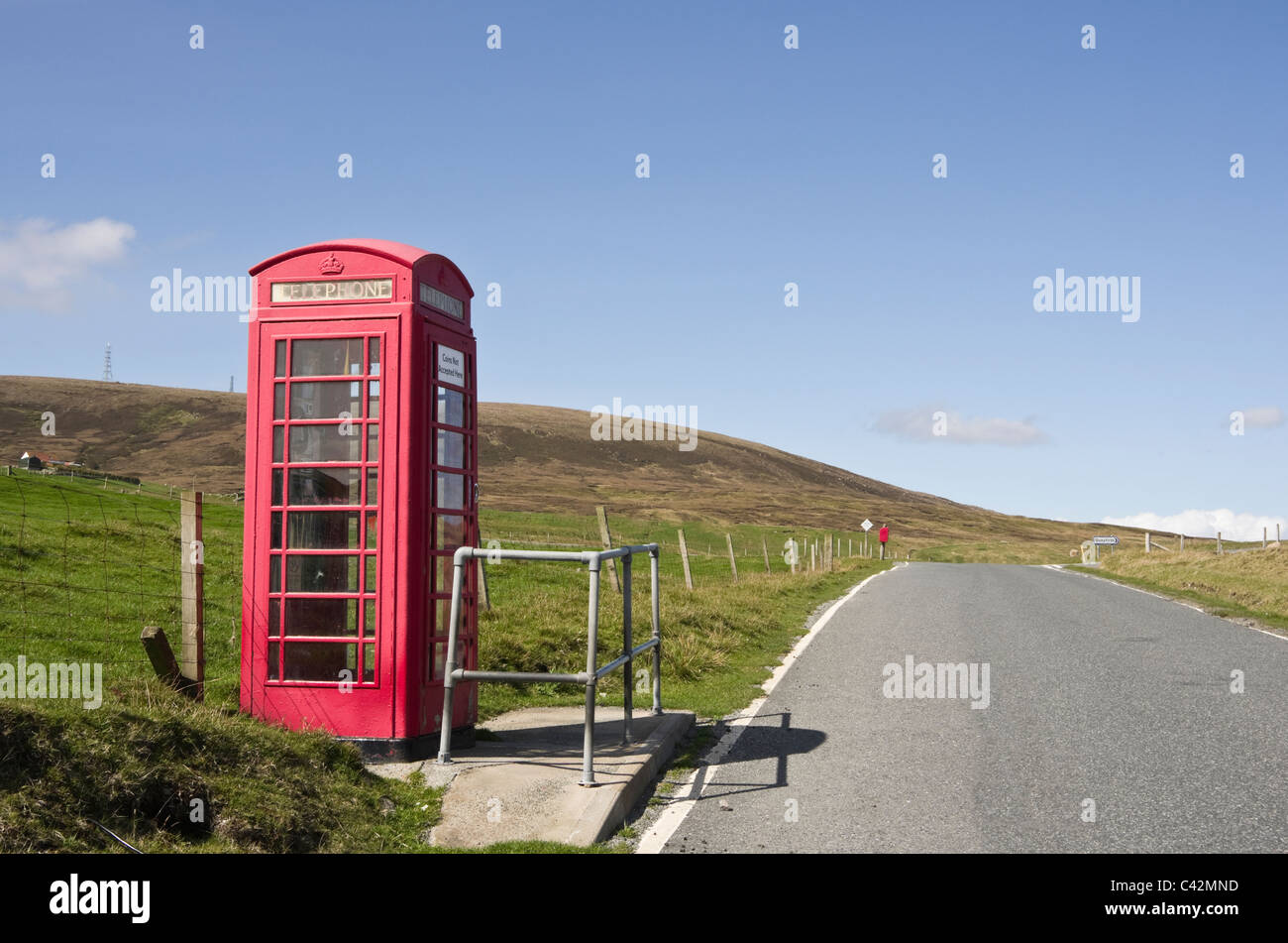 Seule piste empty country road et cabine téléphonique rouge fort. Voe, Northmavine, Shetland, Scotland, UK, Grande-Bretagne. Banque D'Images