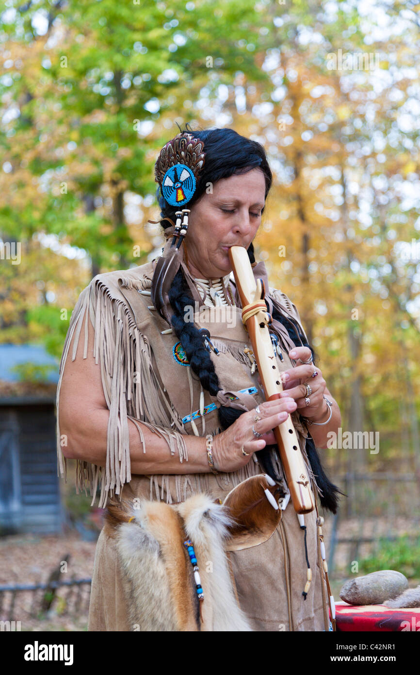 Femme vêtue comme Indien de l'Amérique joue main mesure en bois flûte à Billie Creek Village de Rockville, Maryland, USA Banque D'Images