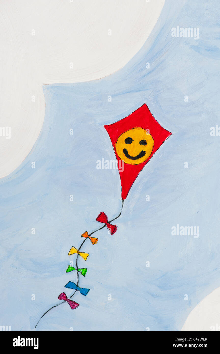 Childs peinture d'un visage souriant heureux sur un cerf-volant dans le ciel Banque D'Images